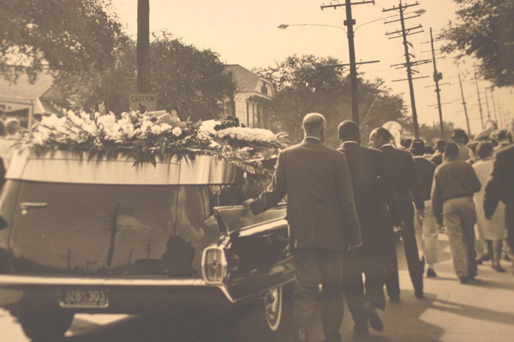 Hearse with flowers and pall bearers